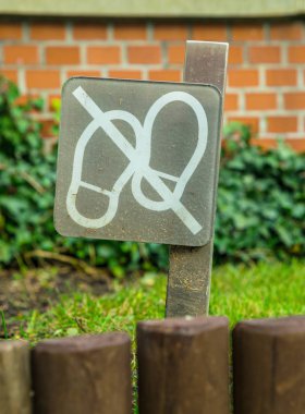 Bahçe ve bahçe işleri. Çimenlerde yürümeyi yasaklayan tabela.
