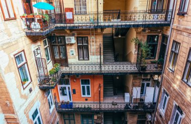 Budapeşte / Macaristan -29 Ağustos 2019: Budapeşte, Macaristan'da eski bir apartmanda merdiven, sahte korkuluk ve kemerli kapı. Eski şehir mahallesinde konut koşulları