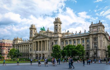 Budapest / Hungary - August 29 2019: Facade of the historic luxury building of the Ethnographic Museum in Budapest, Hungary. Ancient building with columns against the blue sky and green city park