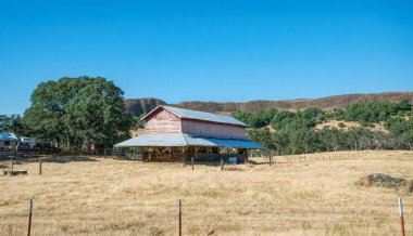 Lodi, California / USA - June 15 2017: old wooden house and farm buildings on a ranch in Ladai, California, USA. Arid California climate and dried grass on pastures. Summer trip to southwest USA