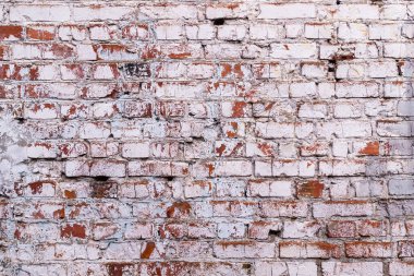 Eski yıpranmış tuğla duvar. Kırmızı tuğlada çatlak boya soyuluyor.