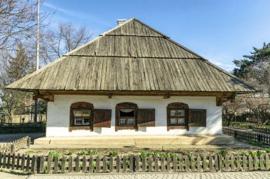  Bahçenin arka bahçesindeki eski geleneksel köy evi. Beyaz kil duvarlar ve tahta çatı