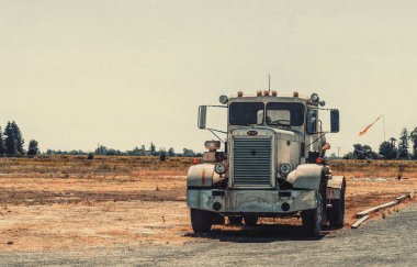 Lodi, California, ABD - 15 Haziran 2017: Lodi, Kaliforniya, ABD 'de eski kırsal ahır ve kuru tarlaların arka planında bir benzin deposu olan eski Peterbilt kamyonu. Geleneksel Amerikan kırsal arazisi