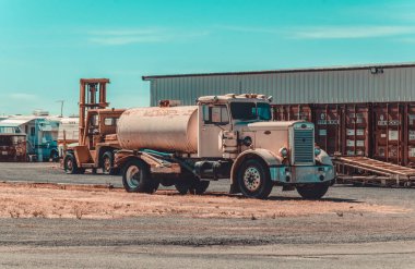 Lodi, California, ABD - 15 Haziran 2017: Lodi, Kaliforniya, ABD 'de eski kırsal ahır ve kuru tarlaların arka planında bir benzin deposu olan eski Peterbilt kamyonu. Geleneksel Amerikan kırsal arazisi