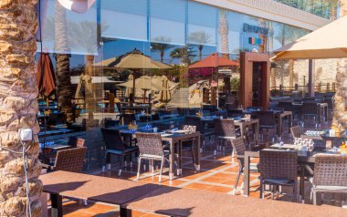 Sharm el Sheikh / Mısır - 3 Aralık 2019: Mısır 'ın Sharm El Sheikh kentindeki bir tatil köyünde güneş havuzu yakınlarındaki bir restoranın masa ve sandalyeleri. Sahil tatili ve servis hepsi dahil.