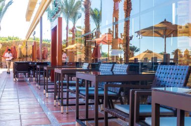 Sharm el Sheikh / Mısır - 3 Aralık 2019: Mısır 'ın Sharm El Sheikh kentindeki bir tatil köyünde güneş havuzu yakınlarındaki bir restoranın masa ve sandalyeleri. Sahil tatili ve servis hepsi dahil.
