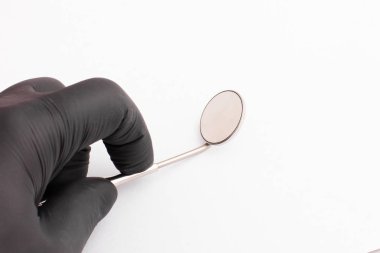 Beyaz arkaplanda erkek eli parıltısı olan dişçi araçları