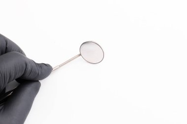 Siyah el parıltısıyla beyaz arkaplanda dişçi araçları