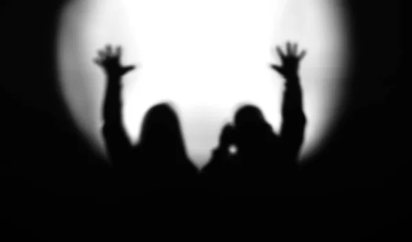 Siyah ve beyaz çift siluetleri ile eller yukarı flo ışığında — Stok fotoğraf