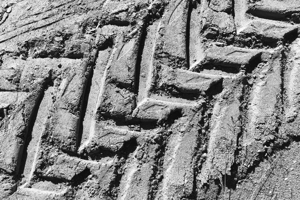 Black and white tire footprint in dirt texture background