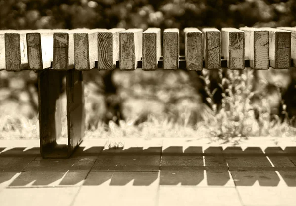 Horizontal sepia park bench bokeh background — Stock Photo, Image
