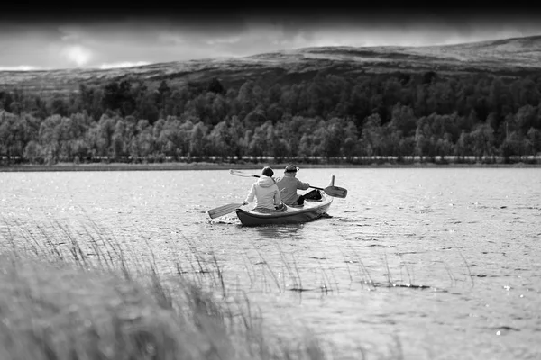 Black and white couple of tourists swimming in boat background — Stock Photo, Image