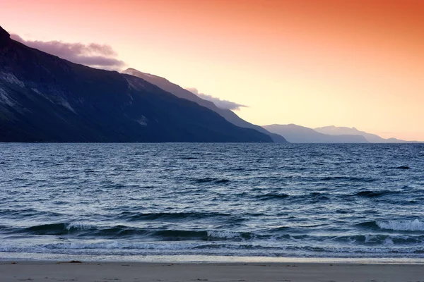 Norveç deniz arka plan günbatımında dağ