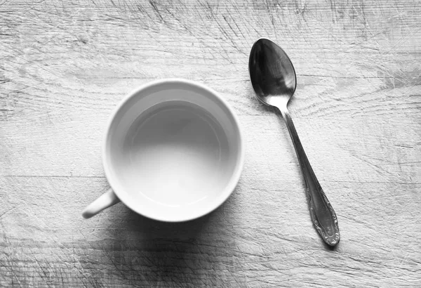 Horizontal taza vacía en blanco y negro con cuchara de fondo bokeh — Foto de Stock