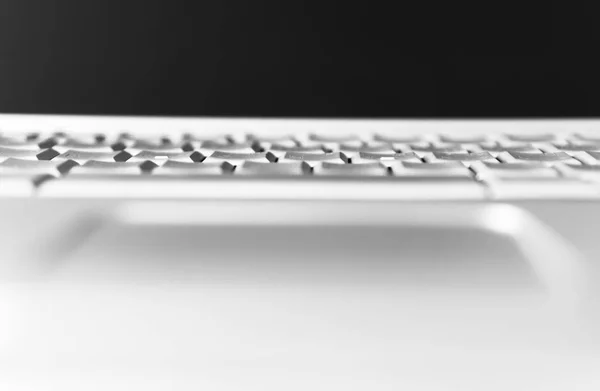 Orizzontale in bianco e nero tastiera del computer portatile bokeh sfondo — Foto Stock