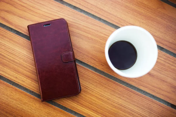 手机与咖啡背景咖啡馆内的木桌 — 图库照片