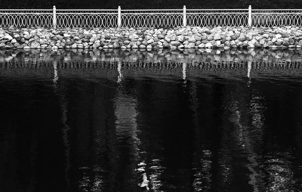 Reflejos horizontales de valla en blanco y negro en la superficie del lago bac — Foto de Stock