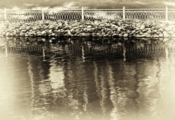 Horizontal sepia vignette park fence near lake background — Stock Photo, Image
