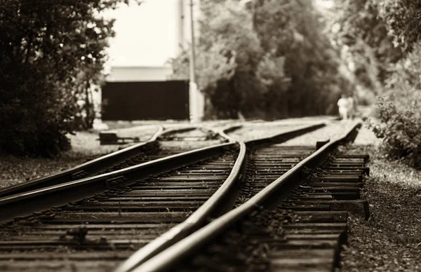 Horizontal black and white sepia railroad track bokeh with peopl — Stock Photo, Image