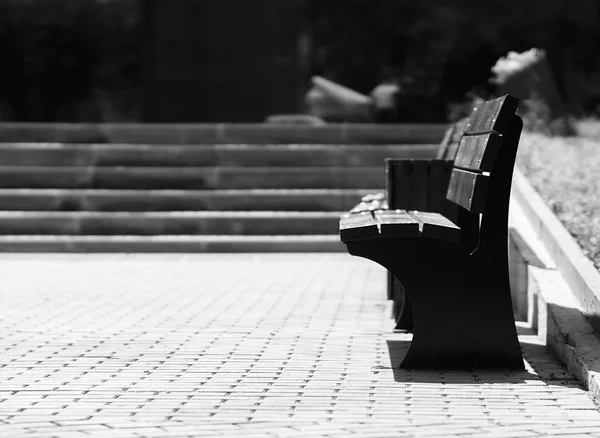 Horizontal black and white right aligned empty bench bokeh backg — Stock Photo, Image