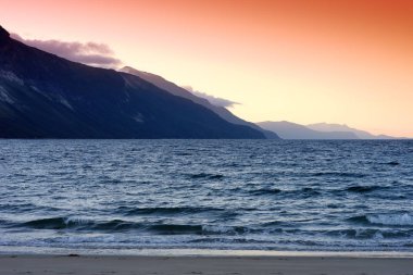 Norveç deniz arka plan günbatımında dağ