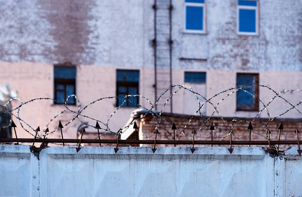 Pared de la prisión con alambre de púas fondo de la ciudad —  Fotos de Stock