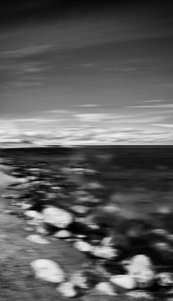 Verticale zwarte en witte dramatische stenige strand bewegingsonscherpte abstra — Stockfoto