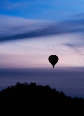 Akşam günbatımında uçan balon silueti