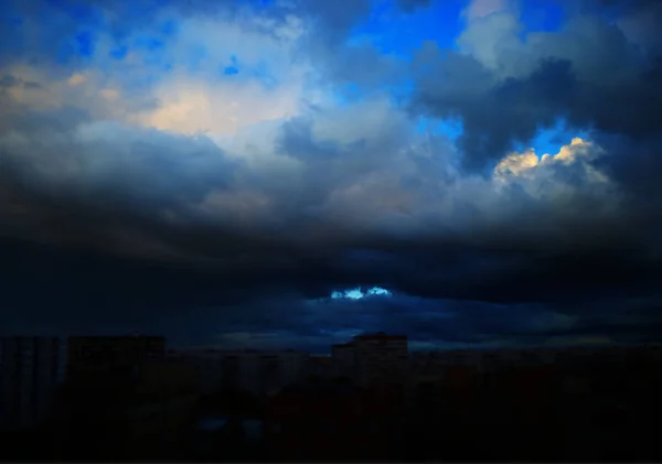 Dramatyczne chmury przykrywające ciemne rozmazane tło miasta — Zdjęcie stockowe