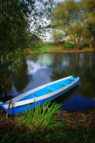 Blå båt vid floden stranden resa bakgrund — Stockfoto