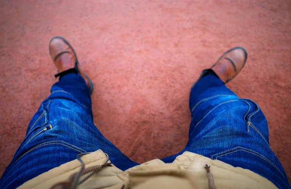 Man i beige rock och blå jeans sitter på parkbänken bakgrund — Stockfoto