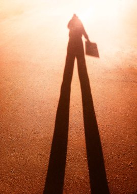 Elinde kağıt parçası olan adamın silueti.