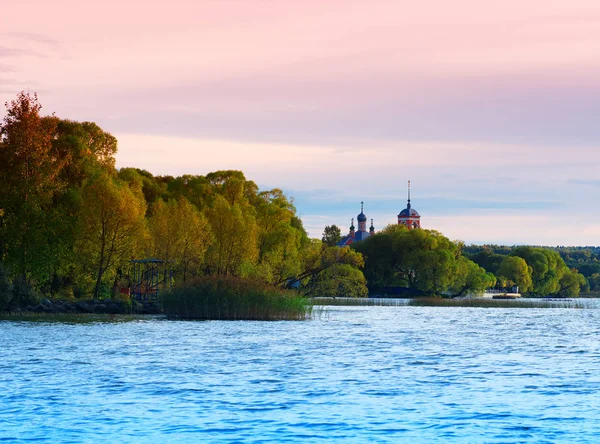 Розовый закат на фоне реки монастыря — стоковое фото