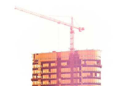 Gün batımında vinç inşa eden gökdelen