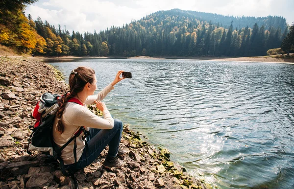 Frau fotografiert mit Smartphone beim Wandern in der Natur — Stockfoto