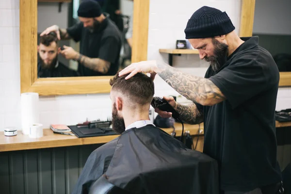 Homem barbudo cortando cabelo e barba no barbeiro local — Fotografia de Stock