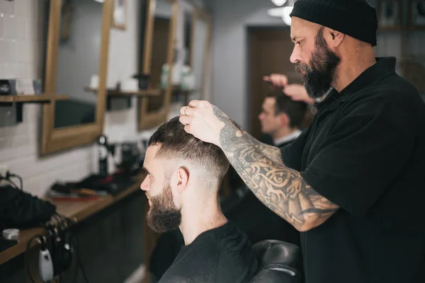 Bearded man getting his hair and beard cut at the local barber s — Stock Photo, Image