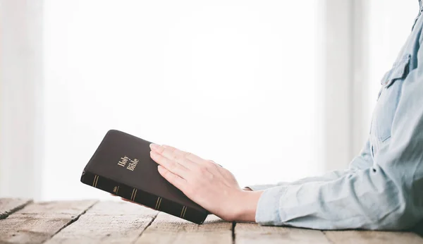 Женщина читает и молится за Библию — стоковое фото