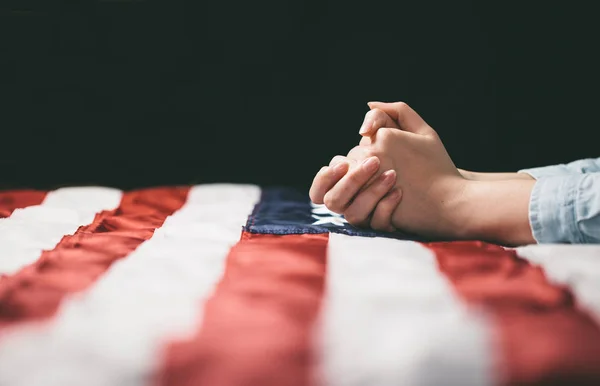 Hands praying over USA flag — Stock Photo, Image