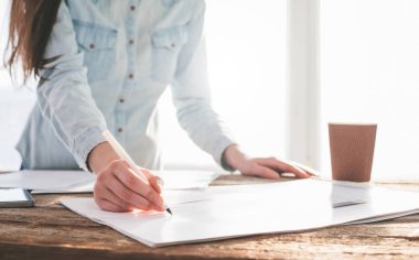 Bir ev planı ile çalışan tasarımcı