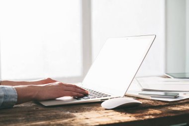 Ahşap bir stand üzerine kapalı dizüstü ve tablet pc üzerinde çalışan kadın