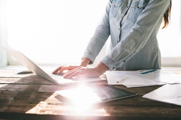 Kvinna som arbetar på en bärbar dator och tablet pc inomhus på en monter — Stockfoto