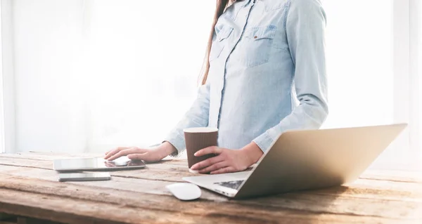 Menina trabalhando em um laptop e tablet pc indoor em um standi de madeira — Fotografia de Stock