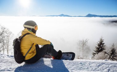 Oturma ve backgro dağ zinciri bakarak snowboarder
