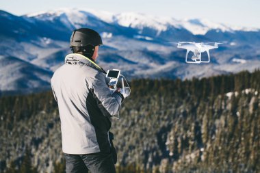 Adam açık havada bir dron dağlarda uçan uzaktan kumanda ile