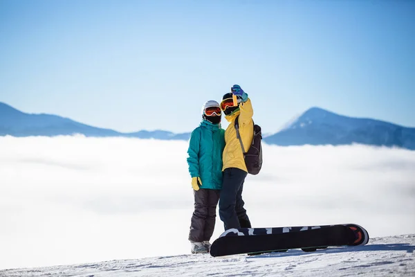 Skifahrer fotografieren sich mit Smartphone über einem Berg — Stockfoto