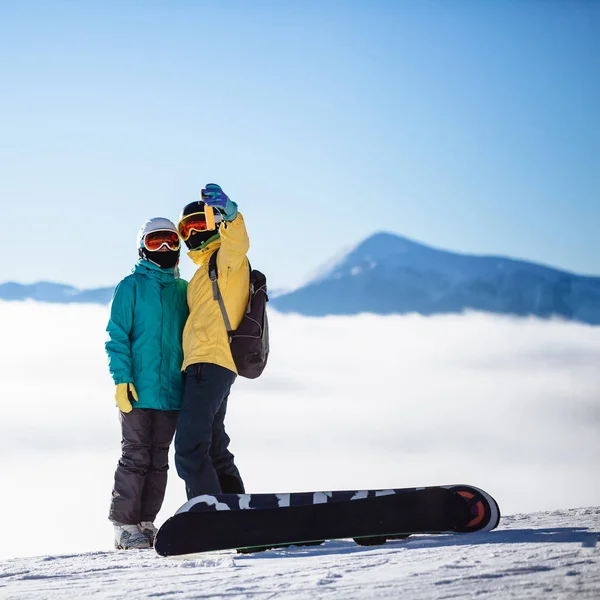 Esquiadores tirando fotos de si mesmos com smartphone sobre uma montagem — Fotografia de Stock