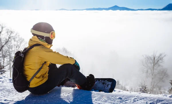 Oturma ve backgro dağ zinciri bakarak snowboarder