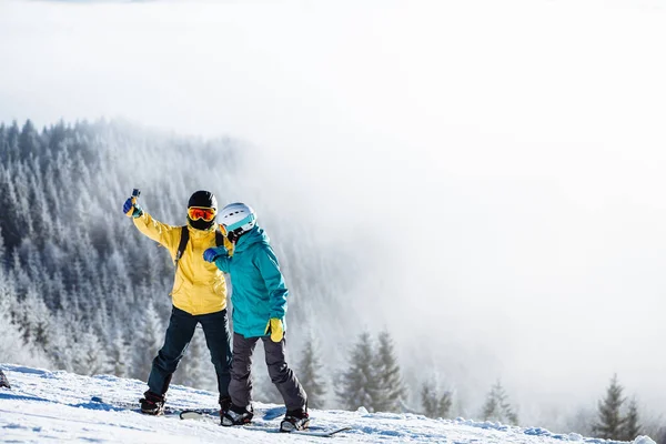 Skifahrer fotografieren sich mit Smartphone über dem Kopf — Stockfoto