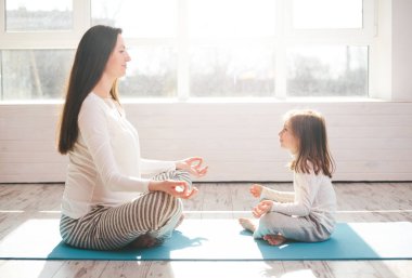 Anne ve bir çocuk evde yoga gidiyor